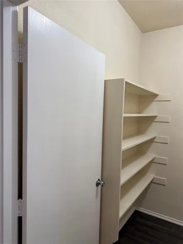 a view of walk in closet with empty racks