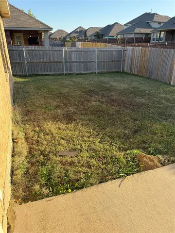 a view of a backyard with a wooden fence
