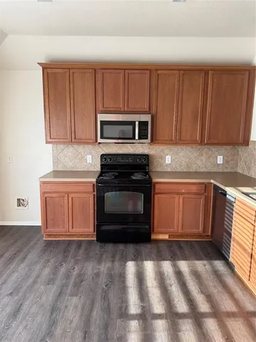 a kitchen with granite countertop a stove top oven and cabinets