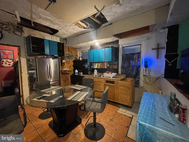 a kitchen with stainless steel appliances kitchen island granite countertop a table chairs and a refrigerator