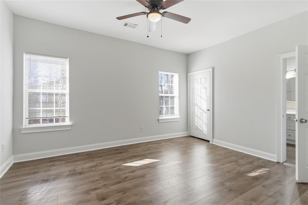 73 Atlanta Avenue Southwest Atlanta, GA 30315 - Photo 14 of 26 an empty room with wooden floor chandelier fan and windows