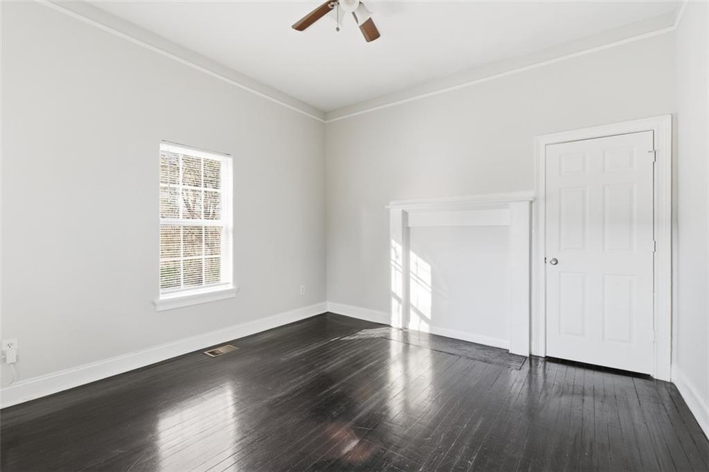 73 Atlanta Avenue Southwest Atlanta, GA 30315 - Photo 10 of 26 an empty room with wooden floor chandelier fan and windows