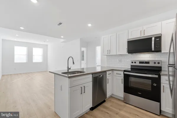 a kitchen with stainless steel appliances granite countertop a stove top oven a sink and dishwasher