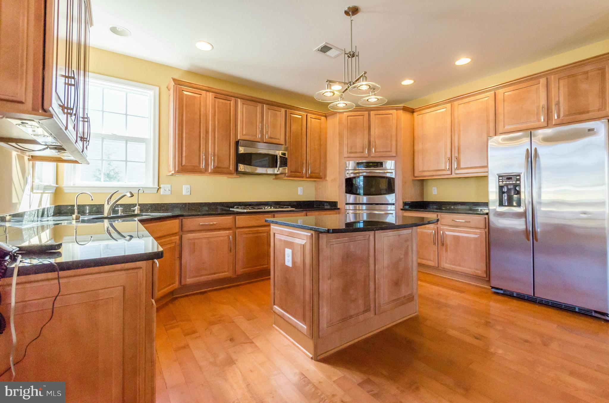 6517 Clarington Road Baltimore, MD 21209 - Photo 12 of 30 a kitchen with stainless steel appliances granite countertop a sink a stove a refrigerator cabinets and a dining table