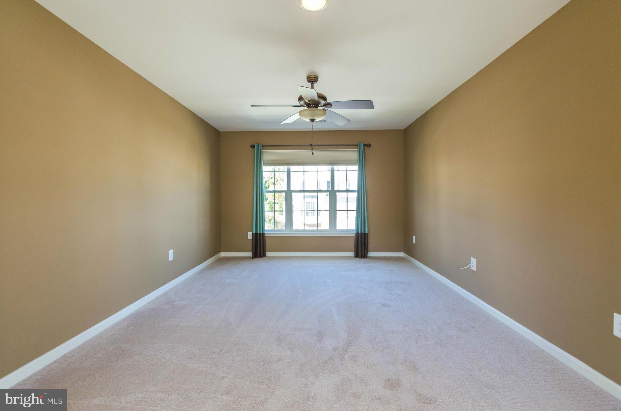 6517 Clarington Road Baltimore, MD 21209 - Photo 15 of 30 an empty room with a window and a chandelier fan