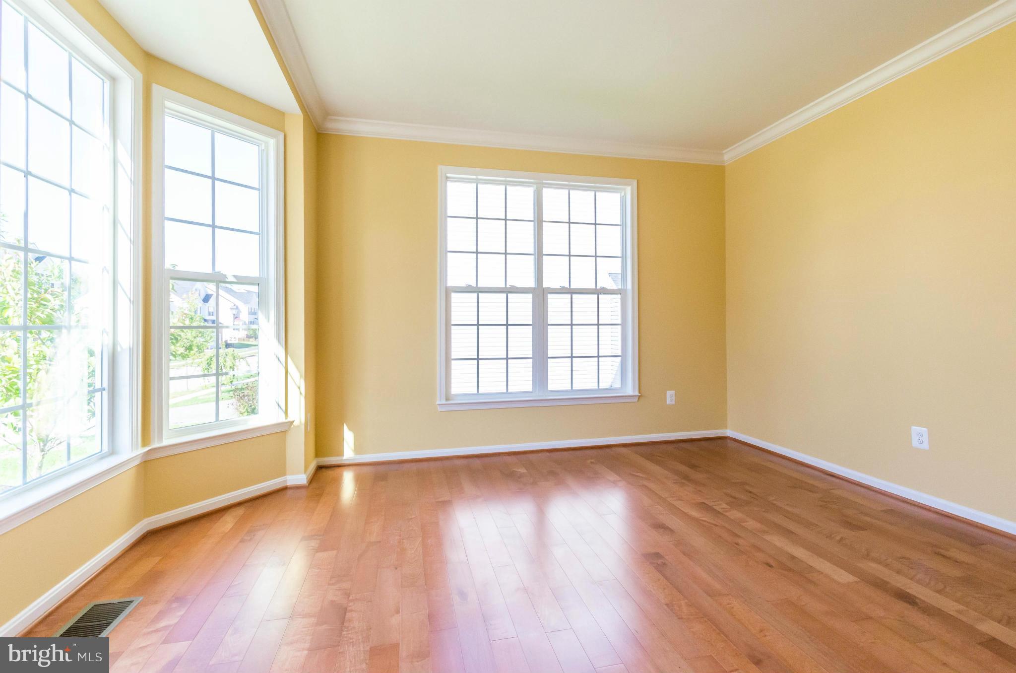 6517 Clarington Road Baltimore, MD 21209 - Photo 4 of 30 a view of an empty room with wooden floor and a window