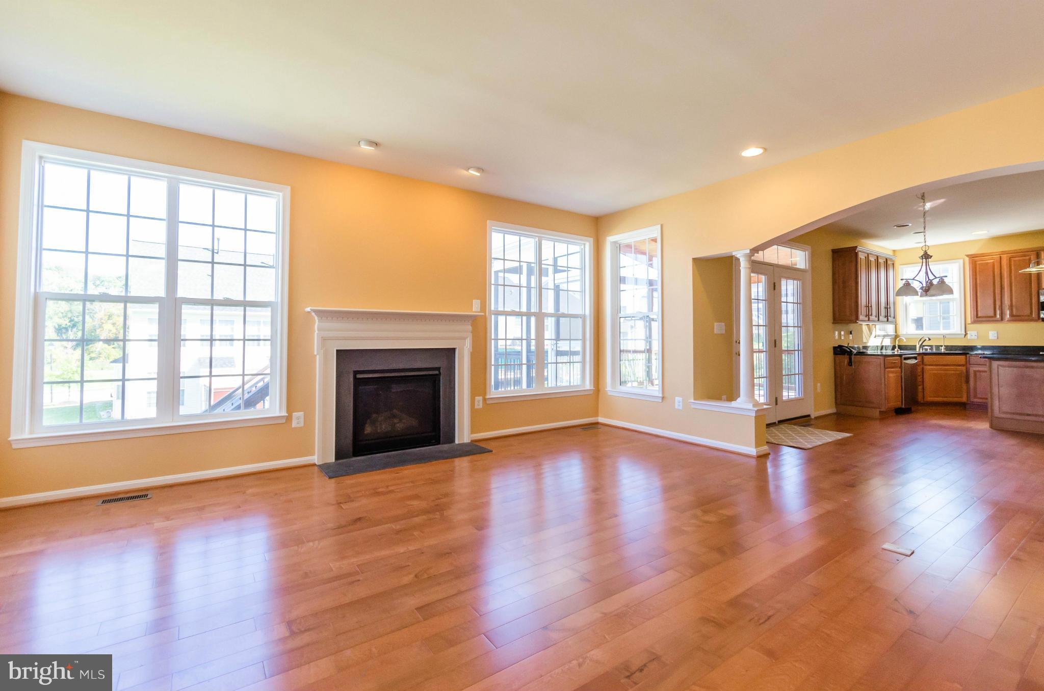 6517 Clarington Road Baltimore, MD 21209 - Photo 8 of 30 an empty room with wooden floor and a fireplace