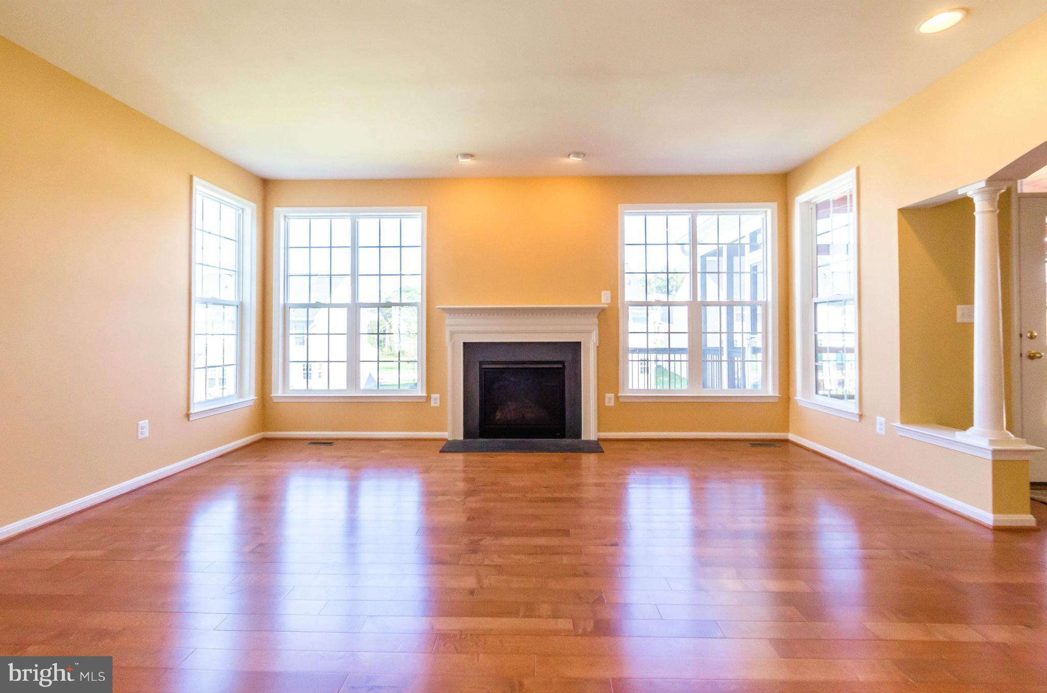 6517 Clarington Road Baltimore, MD 21209 - Photo 9 of 30 a view of an empty room with wooden floor and a window