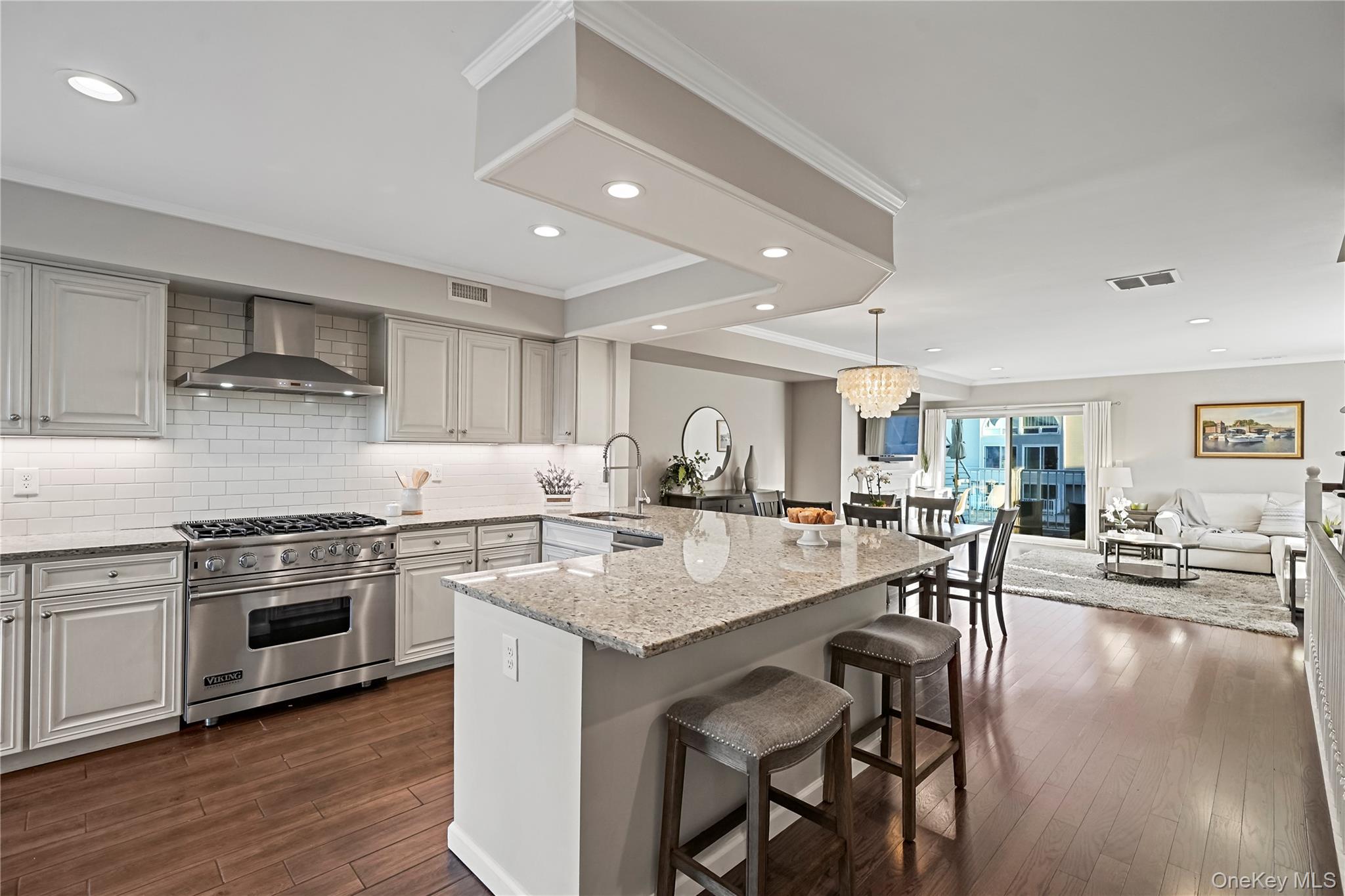 21 Deepwater Way Bronx, NY 10464 - Photo 2 of 27 a open kitchen with stainless steel appliances granite countertop a stove top oven a sink a dining table and chairs with wooden floor