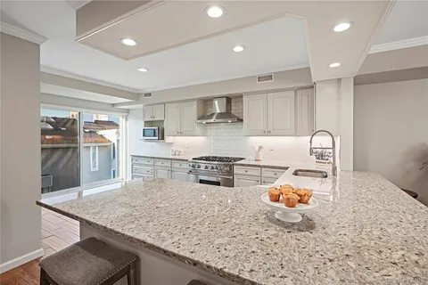a kitchen with a sink a stove and chairs