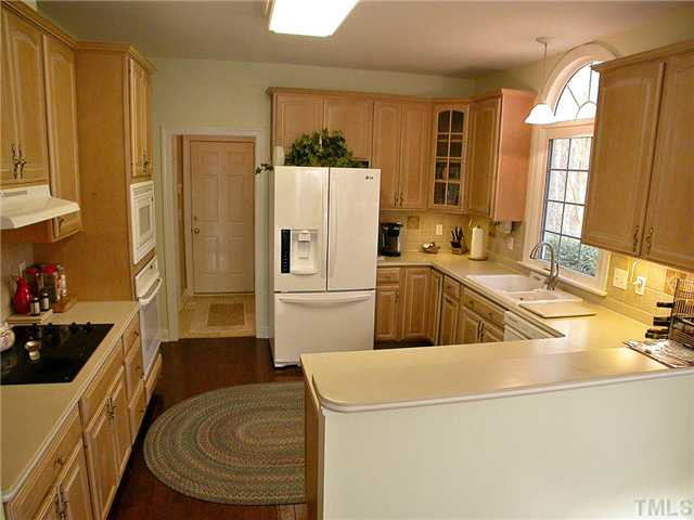 6812 Cool Pond Road Raleigh, NC 27613 - Photo 8 of 25 Chef's Kitchen has Hardwood Floors, Solid-surface Countertops and Eat-at Bar Kitchen