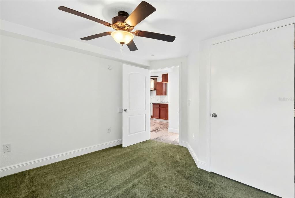 1110 Southwest Fort King Street Ocala, FL 34471 - Photo 12 of 30 an empty room with a ceiling fan and carpet