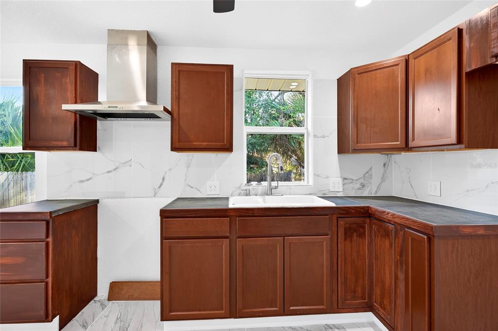 1110 Southwest Fort King Street Ocala, FL 34471 - Photo 17 of 30 a kitchen with stainless steel appliances granite countertop wooden cabinets a sink and dishwasher