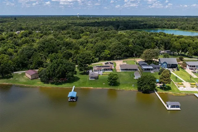 an aerial view of a house with a garden and lake view