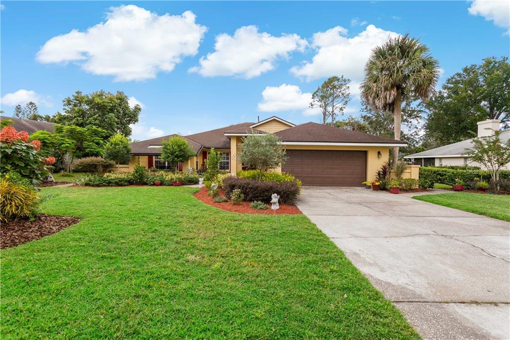 a front view of a house with a garden and trees