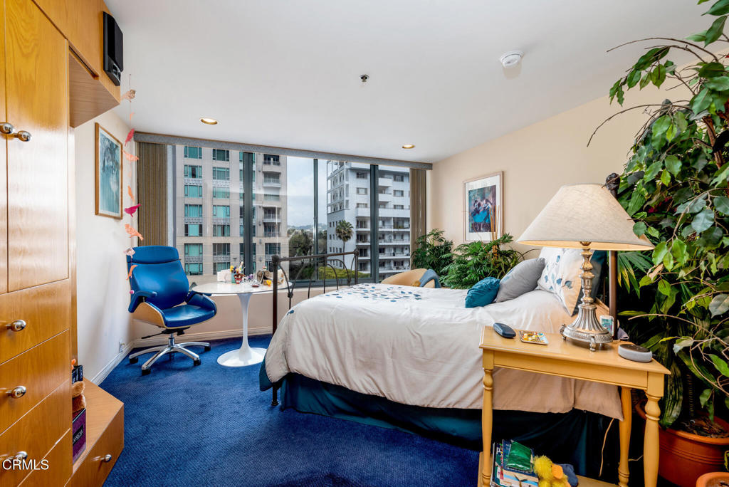 10724 Wilshire Boulevard, Unit 607 Los Angeles, CA 90024 - Photo 12 of 33 a bedroom with furniture and a large window