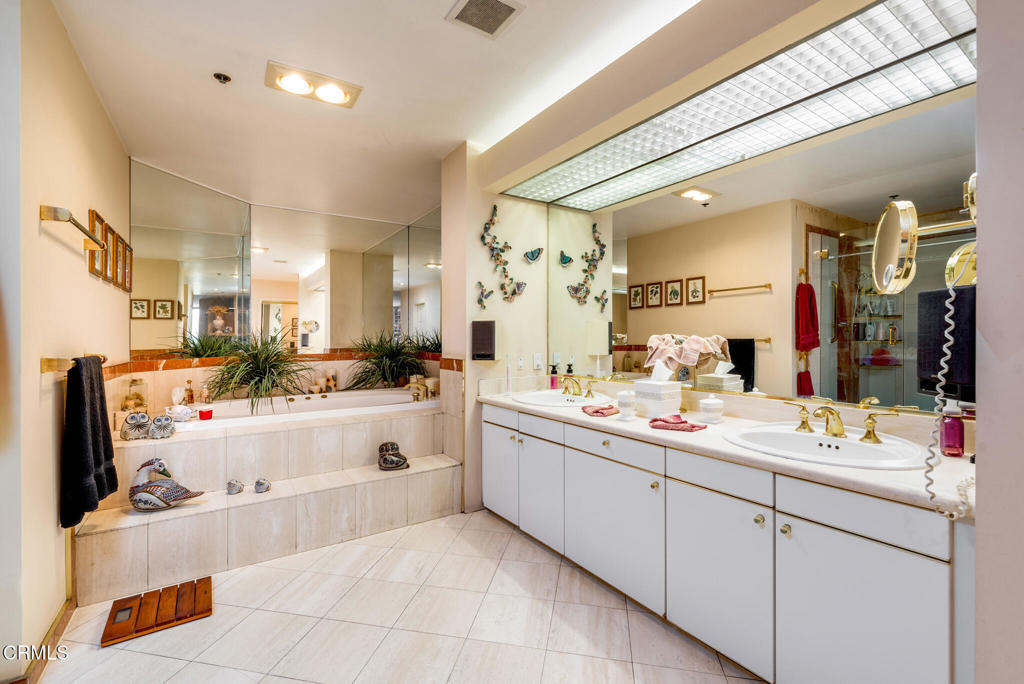 10724 Wilshire Boulevard, Unit 607 Los Angeles, CA 90024 - Photo 24 of 33 a large white bathroom with a large tub sink vanity and mirror