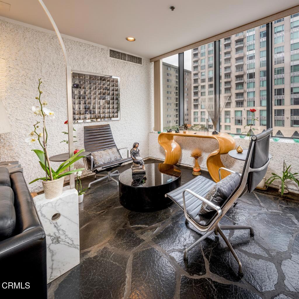 10724 Wilshire Boulevard, Unit 607 Los Angeles, CA 90024 - Photo 4 of 33 a living room with furniture and floor to ceiling windows