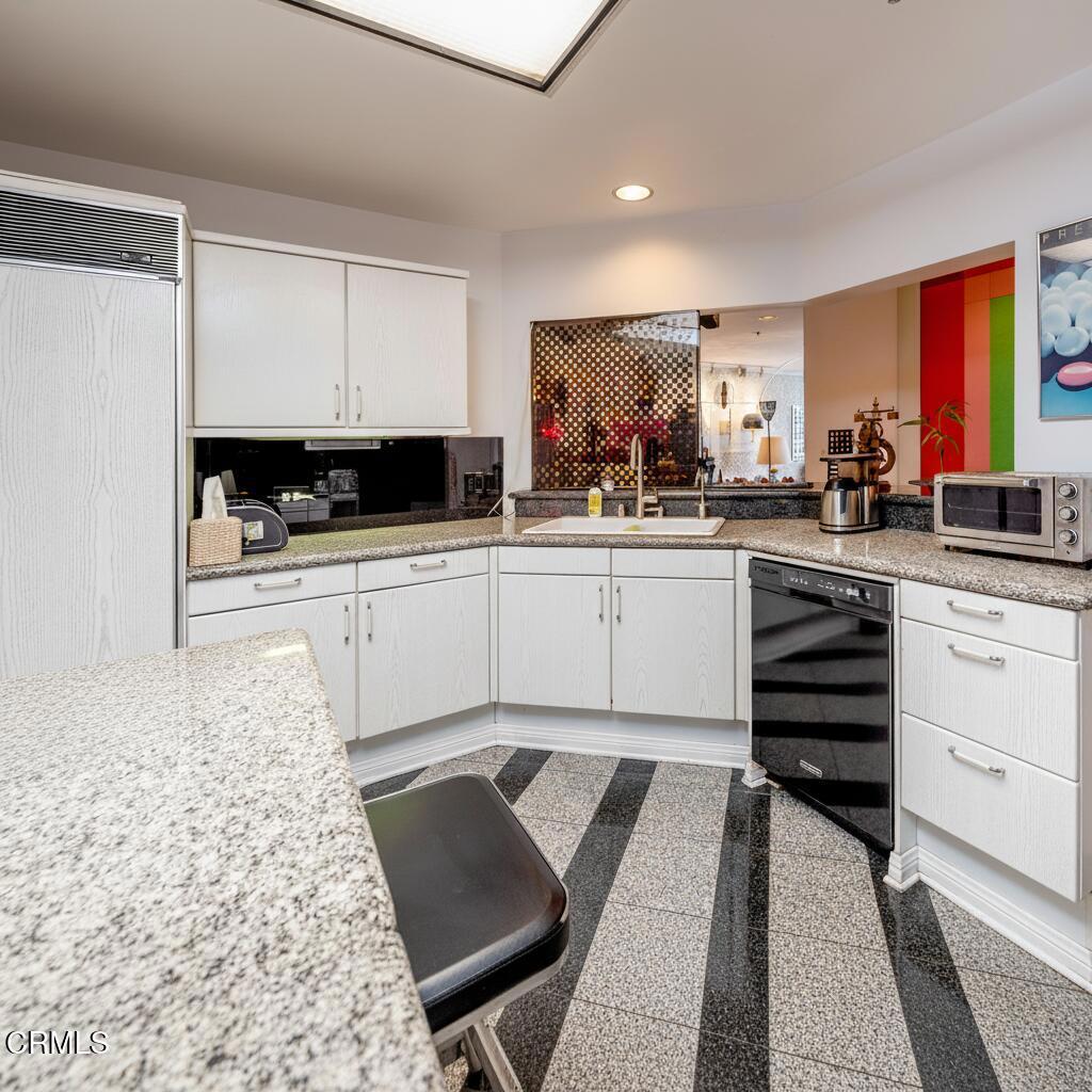 10724 Wilshire Boulevard, Unit 607 Los Angeles, CA 90024 - Photo 5 of 33 a kitchen with stainless steel appliances kitchen island granite countertop a sink and cabinets