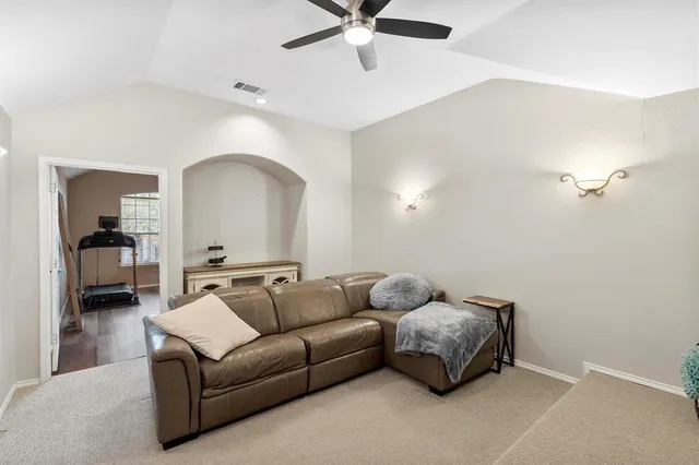 a living room with furniture and a ceiling fan