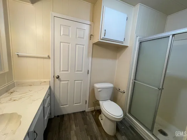 a bathroom with a granite countertop sink toilet and shower