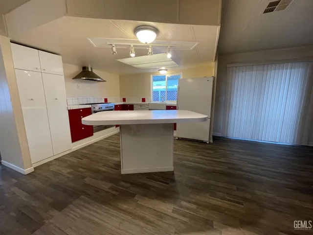 a kitchen with kitchen island a sink appliances and cabinets