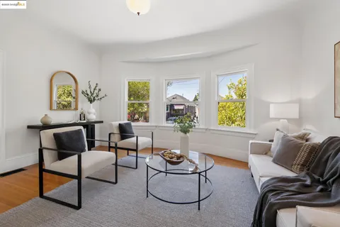 a living room with furniture a dining table and a potted plant