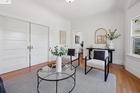 a dining room with wooden floor a chandelier a wooden table and chairs