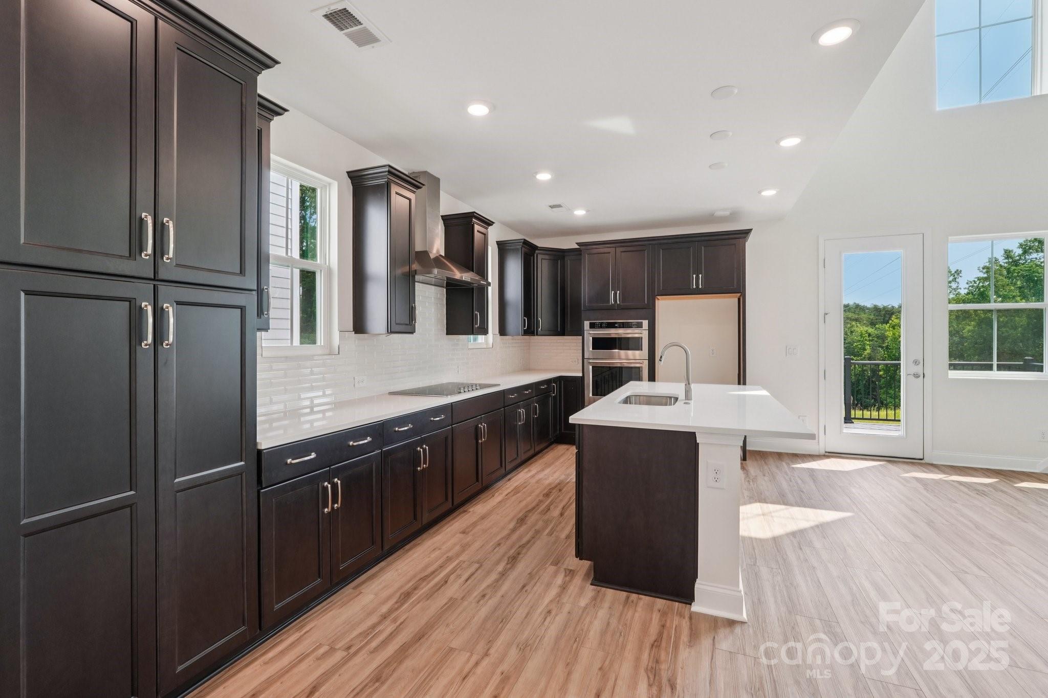 716 Flare Drive Tega Cay, SC 29708 - Photo 4 of 19 a kitchen with stainless steel appliances granite countertop a refrigerator a sink dishwasher a stove and a dining table with wooden floor
