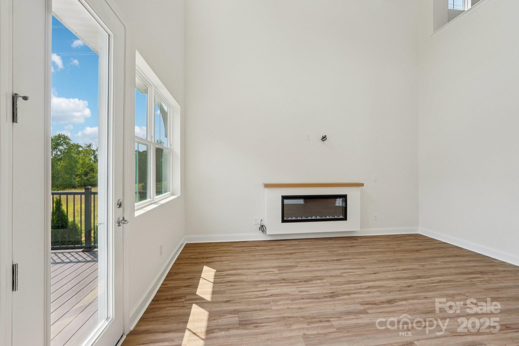 716 Flare Drive Tega Cay, SC 29708 - Photo 8 of 19 a view of a hallway with wooden floor and a floor to ceiling window