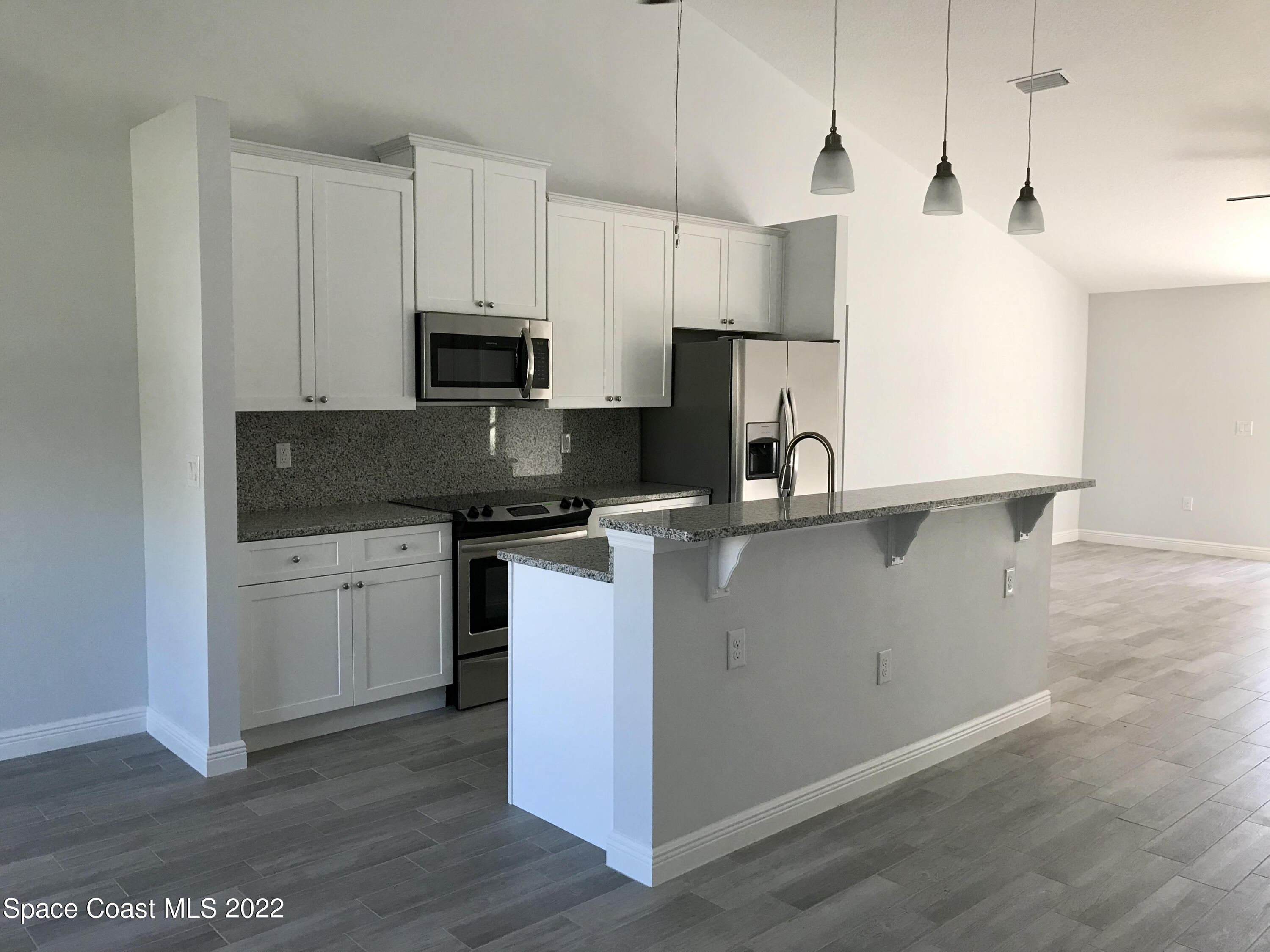 4035 Grant Line Road Mims, FL 32754 - Photo 6 of 18 a kitchen with granite countertop a sink a counter top space and cabinets