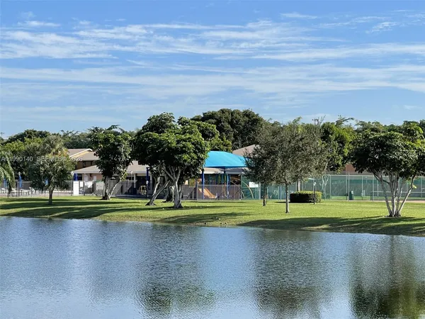 a view of a swimming pool with lawn chairs and a big yard