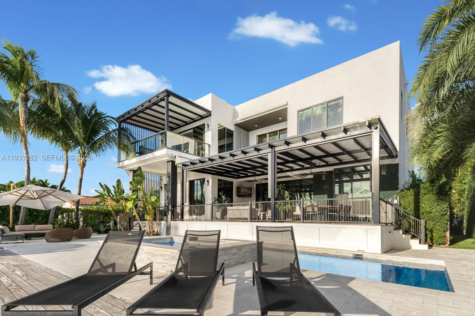 a view of a patio with couches table and chairs with potted plants and palm trees