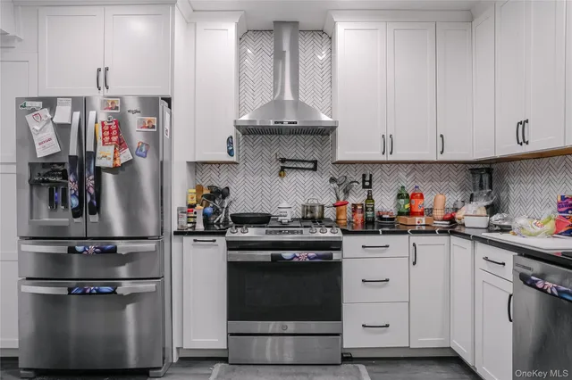 a kitchen with stainless steel appliances granite countertop a stove and cabinets