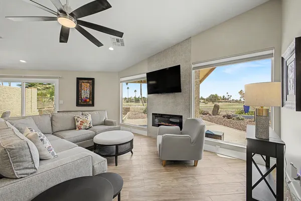 a living room with furniture a fireplace and a flat screen tv