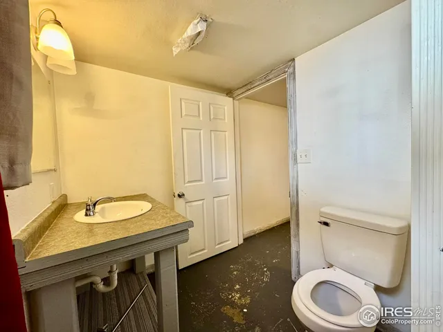 a bathroom with a granite countertop toilet sink and mirror