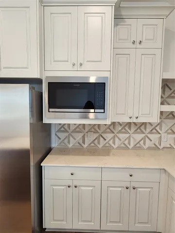a kitchen with white cabinets and sink