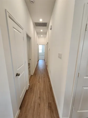 a view of a hallway with wooden floor