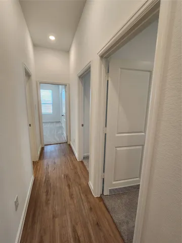 a view of hallway with wooden floor