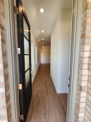 a view of a hallway with wooden floor and staircase