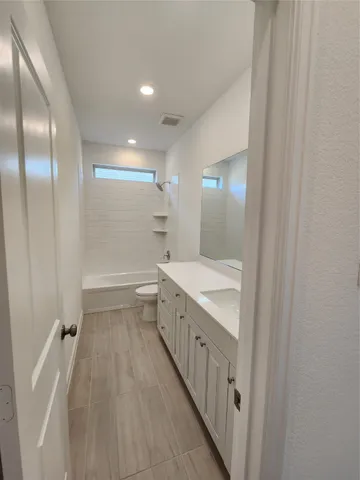 a bathroom with a granite countertop sink a toilet and a mirror