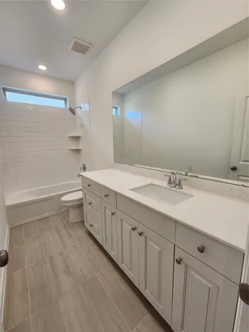 a bathroom with a double vanity sink a toilet and a mirror
