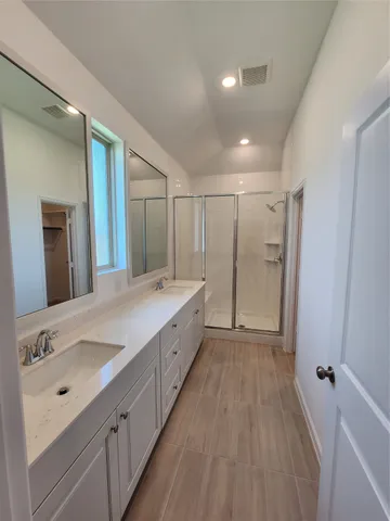 a spacious bathroom with a double vanity sink and mirror