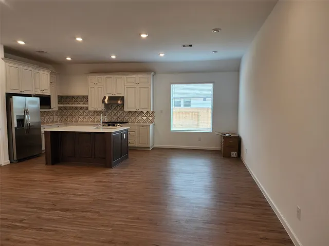 a large kitchen with stainless steel appliances granite countertop a stove a sink and a refrigerator