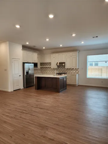 a large kitchen with stainless steel appliances granite countertop a large counter top and a oven