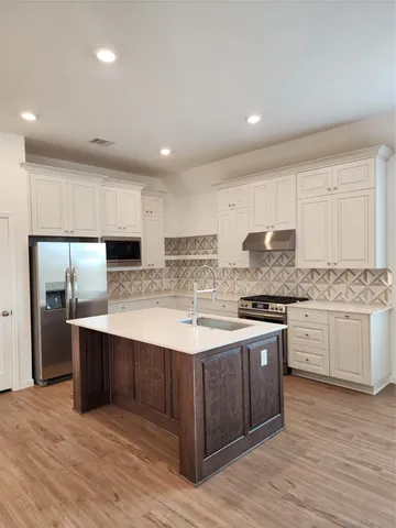 a kitchen with stainless steel appliances granite countertop a sink stove and refrigerator