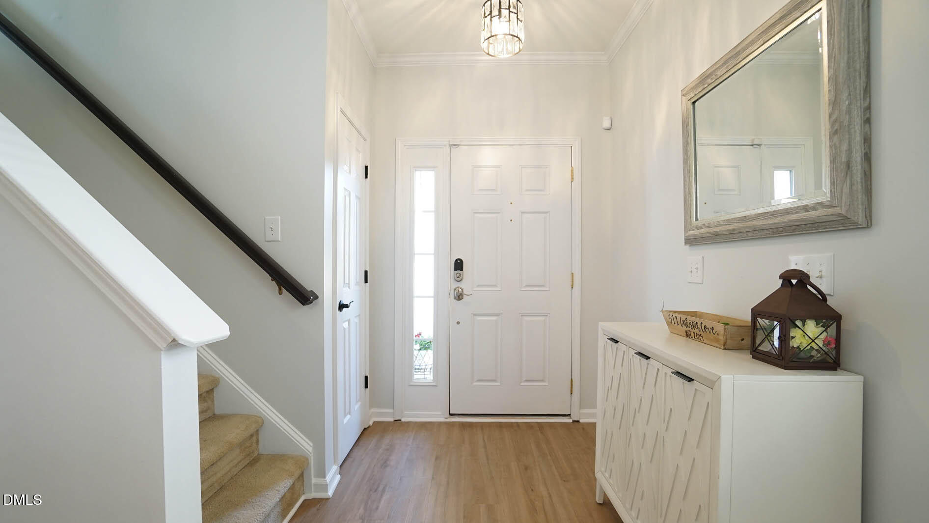 311 Inkster Cove Raleigh, NC 27603 - Photo 5 of 39 a view of a hallway to a livingroom with wooden floor and staircase