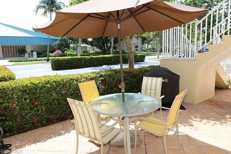 940 3rd Street South, Unit 101 Naples, FL 34102 - Photo 1 of 20 View of patio / terrace featuring stairway, outdoor dining area, and grilling area