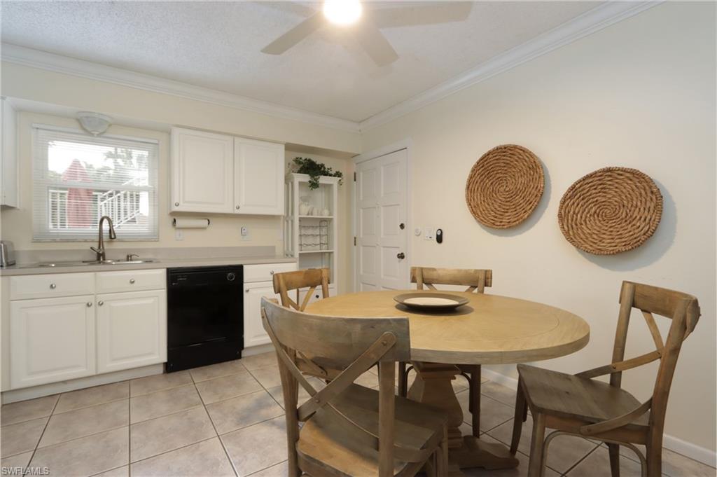940 3rd Street South, Unit 101 Naples, FL 34102 - Photo 11 of 20 Kitchen featuring light countertops, white cabinetry, dishwasher, light tile patterned floors, and ornamental molding