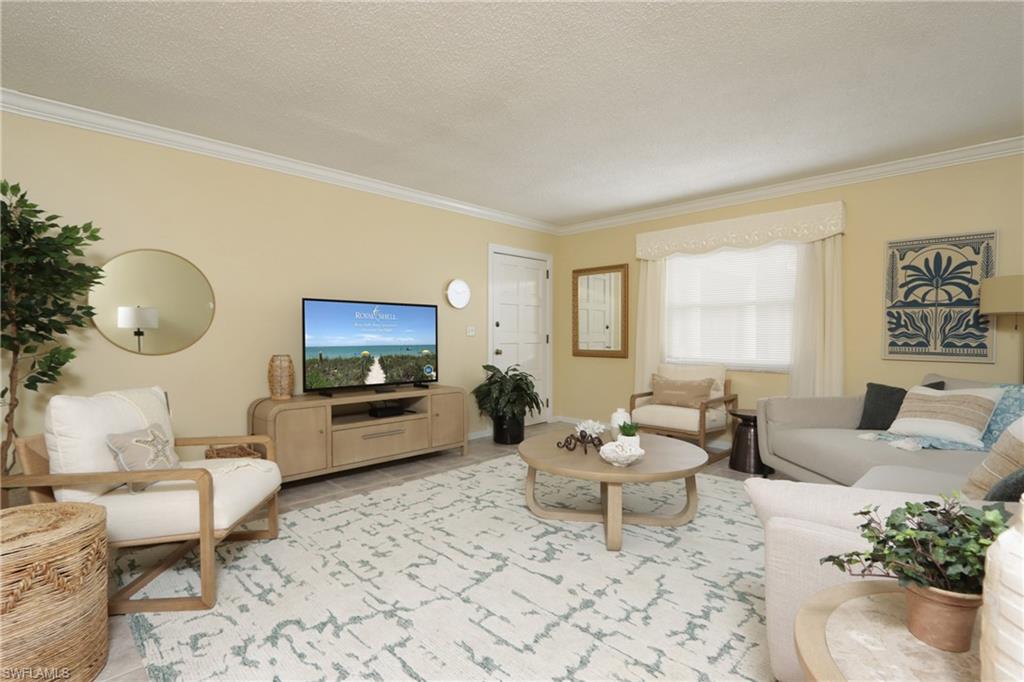 940 3rd Street South, Unit 101 Naples, FL 34102 - Photo 13 of 20 Living room with crown molding and a textured ceiling